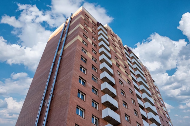 Baksteen nieuwe gebouwen met meerdere verdiepingen tegen een mooie bewolkte hemel.