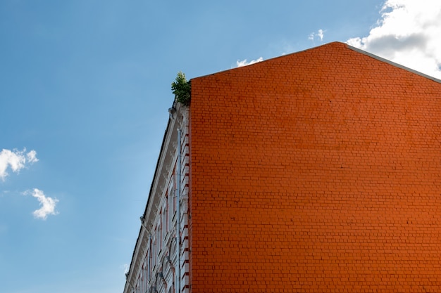 Bakstenen huis van een oud gebouw tegen de blauwe hemel.