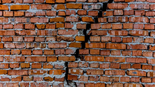 Bakstenen muur met barstmuur achtergrondtextuur het concept het oude huis