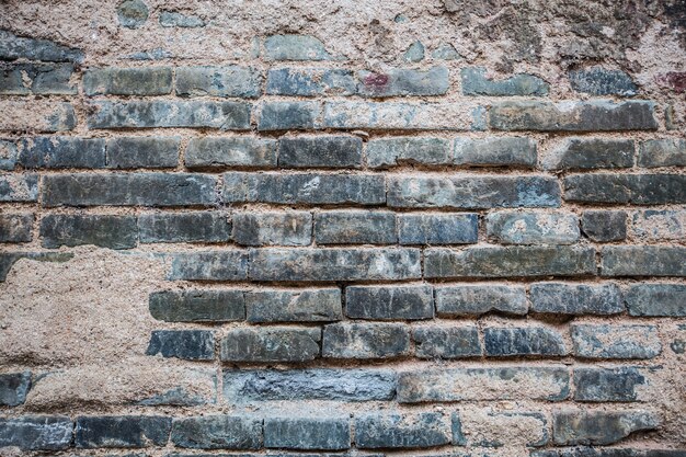 Bakstenen muur met gebroken cement