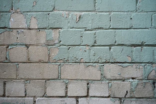 Bakstenen muur met groene afbladderende verf