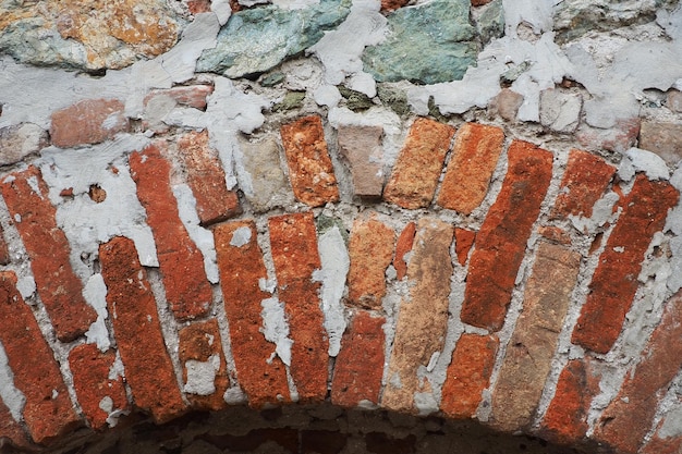 Bakstenen muur van een oud fort Ongelijke rode en bruine bakstenen met cement Baksteen achtergrond