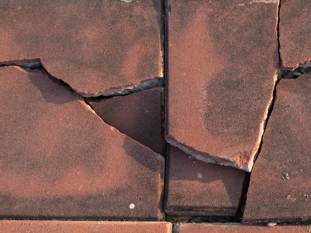 Foto bakstenen vloer met vierkant gesneden en gebroken. close-up shot van het verbrijzelde betegelde oppervlak.