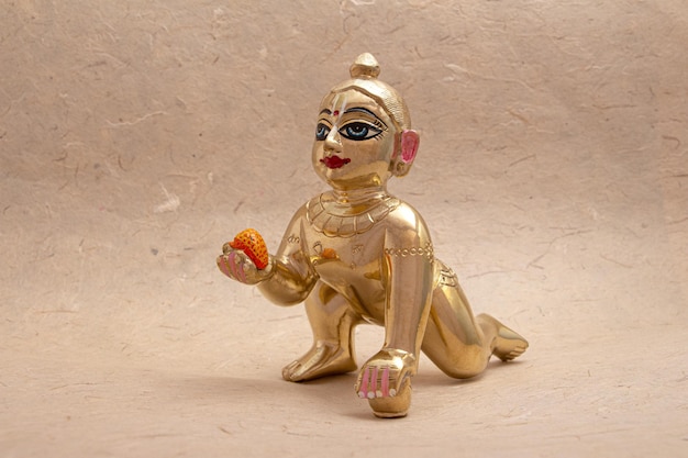 Bal krishna laddu gopal statua in ottone lato rivolto verso sfondo bianco