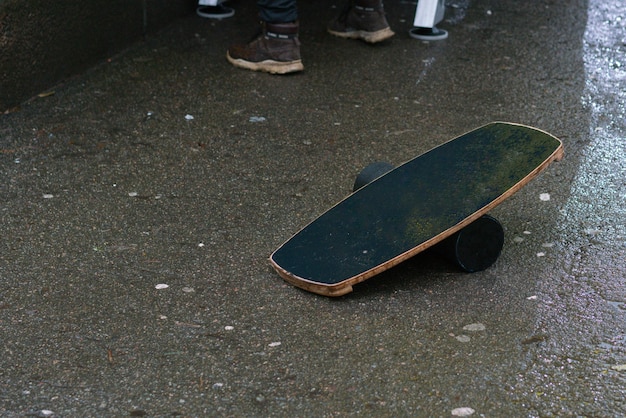 A balance board stands empty on the asphalt on the street outdoor Rainy weather Strength Strong Trainer Training Health Body Attractive Lifestyle Steady Flat Tool