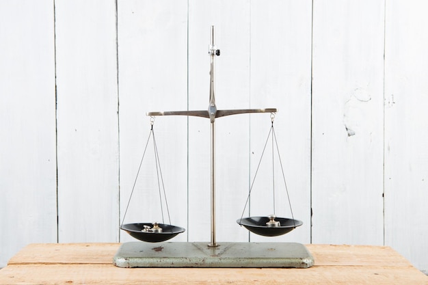 Balance scales on white wooden background