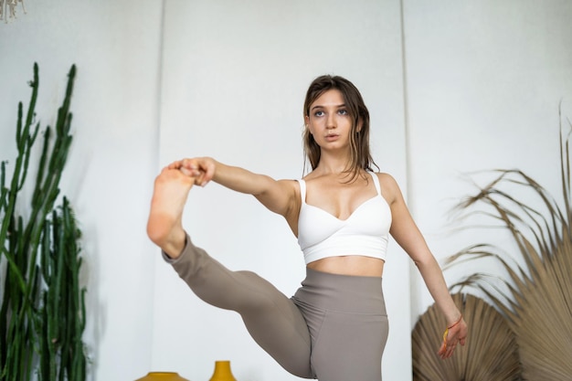 신체 유연성을 위한 균형 스트레칭 운동 한 젊은 여성이 취미 스튜디오에서 요가를 하고 있습니다