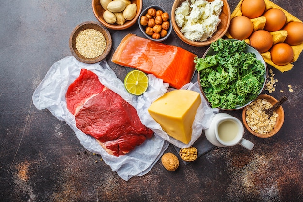 Balanced diet food background. Protein foods: fish, meat, cheese, quinoa, nuts on dark background.