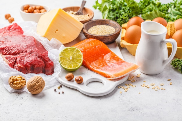사진 균형 잡힌 식단 음식 배경입니다. 단백질 음식 : 생선, 고기, 치즈, 노아, 흰색 배경에 견과류.