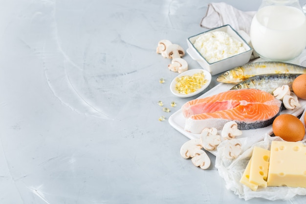 Balanced diet nutrition, healthy eating concept. Assortment of food sources rich in vitamin d, salmon, dairy products, milk, eggs, cheese, mushrooms, sardines on a kitchen table. Copy space background