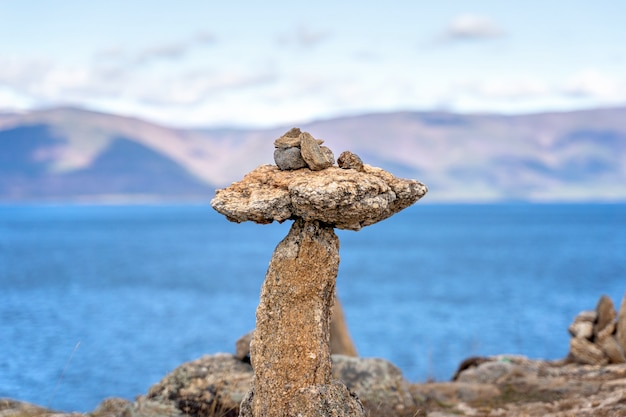 Фото Сбалансированные каменные пирамиды на берегу озера как концепция баланса и гармонии