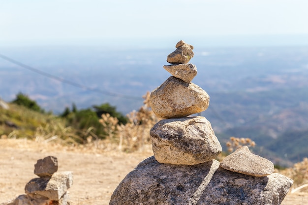Фото Сбалансированные камни стоят на холме с видом на алгарве португалия