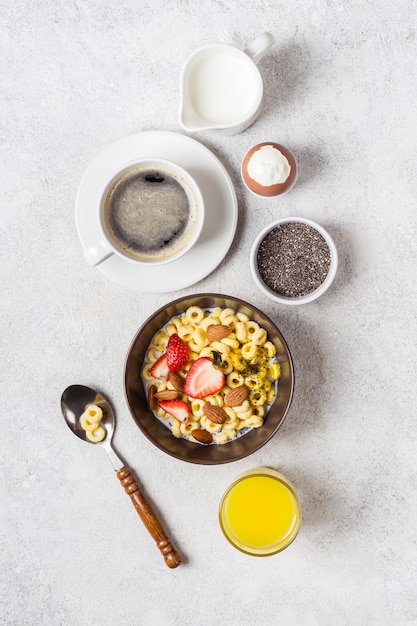 Сбалансированный традиционный завтрак и ингредиенты. Цельнозерновые кольца чирио, кофе, апельсиновый сок и яйцо.