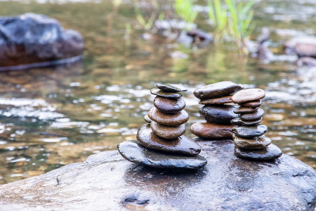 Photo balanced zen rock stacks in a creek,view of a creek with stacked stones on a rock