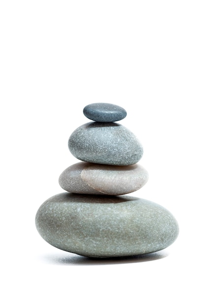 Сбалансированные дзен-камни на белом фоне Вертикальное фото