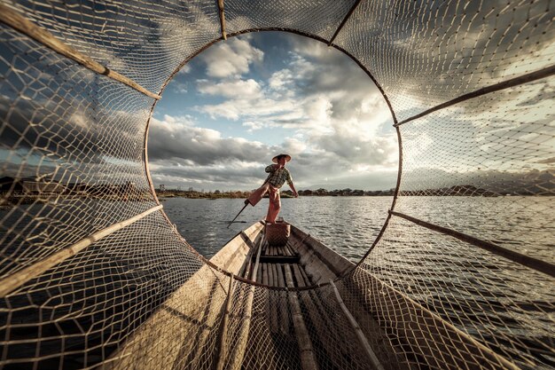 Foto pescatore in equilibrio attraverso la rete