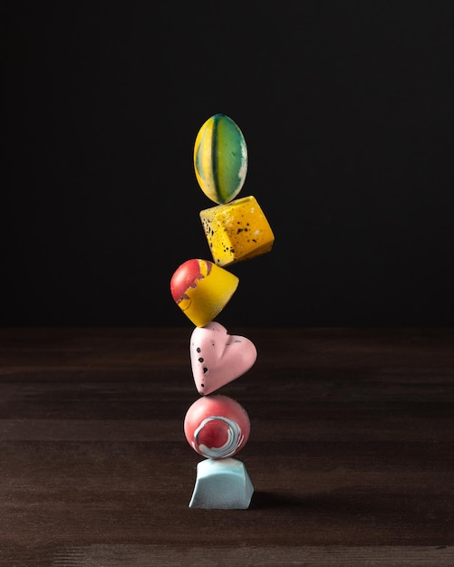 balancing multicolored designer various shapes chocolates