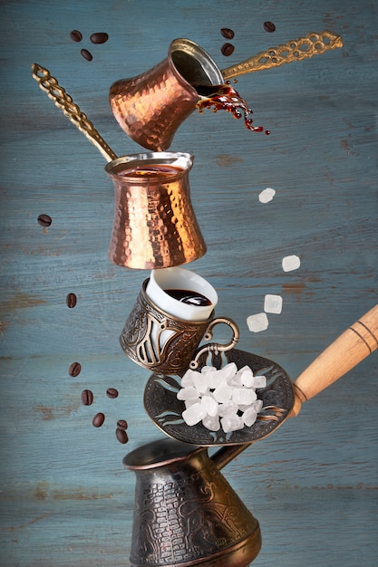 Balancing pyramid of jezves, turkish coffee pots and cups on dark