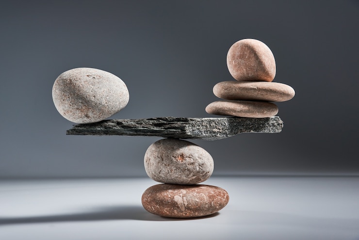 Photo balancing pyramid of sea pebbles on a gray background the concept of harmony and balance