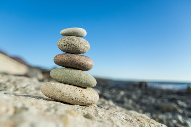 Balancing sea stone on beach background