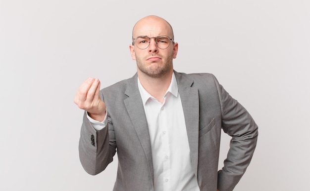 Bald businessman making capice or money gesture, telling you to pay your debts!