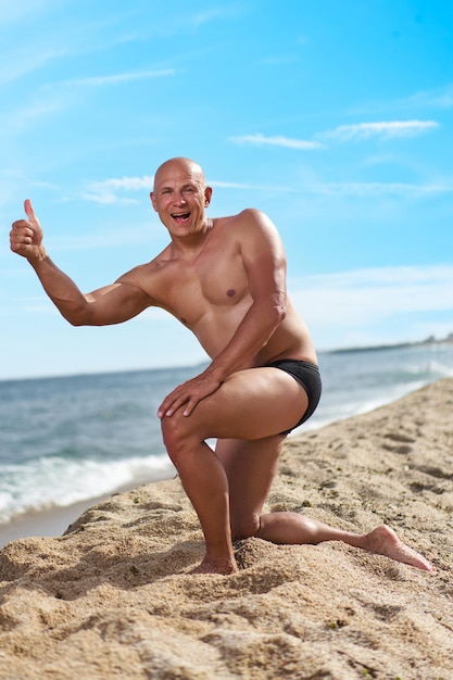 Bald man on the beach by the sea on vacation