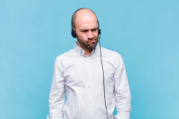 Bald man feeling confused and doubtful, wondering or trying to choose or make a decision