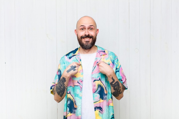 Bald man feeling happy, surprised and proud, pointing to self with an excited, amazed look