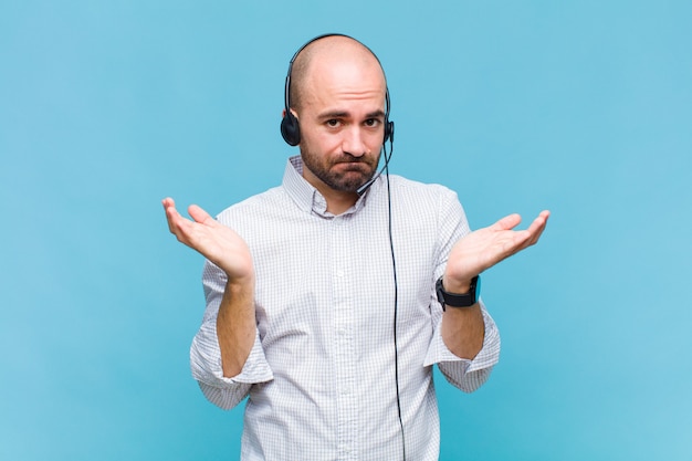 Bald man feeling puzzled and confused, doubting, weighting or choosing different options with funny expression