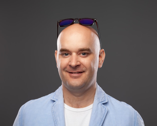 Photo bald man on a gray wall