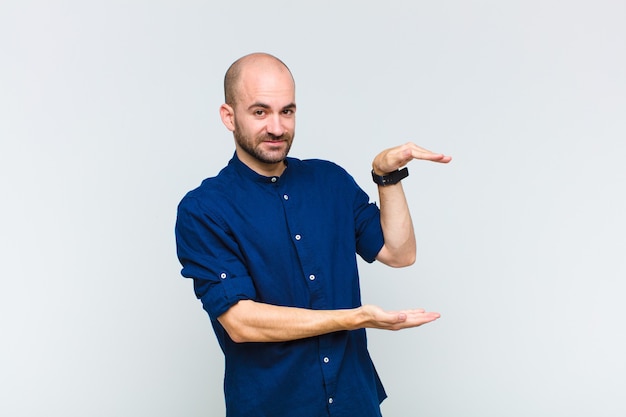 Bald man holding an object with both hands