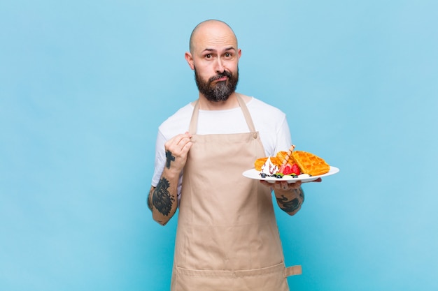 Bald man looking arrogant, successful, positive and proud, pointing to self