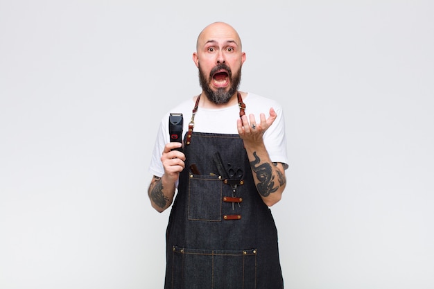 Bald man looking desperate and frustrated, stressed, unhappy and annoyed, shouting and screaming