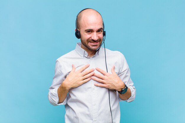 Bald man looking happy, surprised, proud and excited, pointing to self