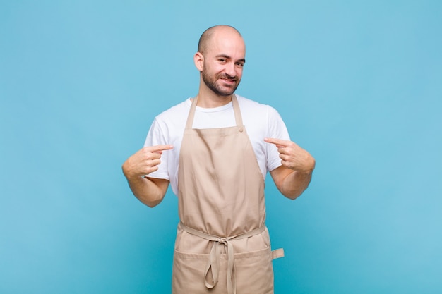 Bald man looking proud pointing to self