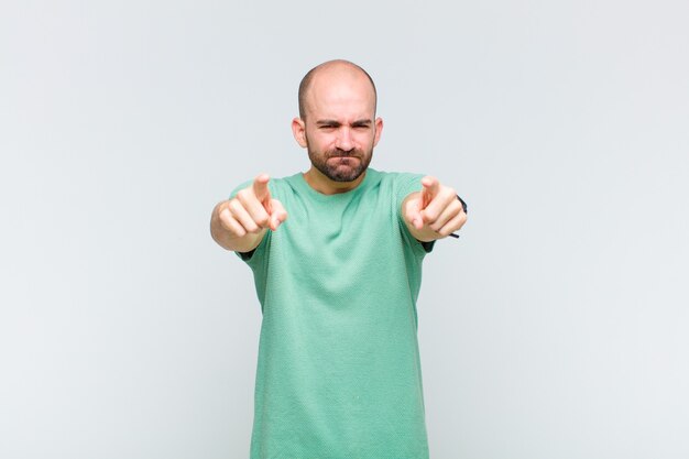 Bald man pointing forward with both fingers