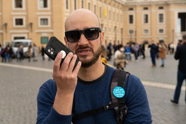 Bald man sending voice message from his mobile phone