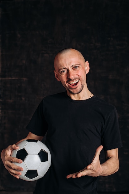 Bald man showing soccer ball