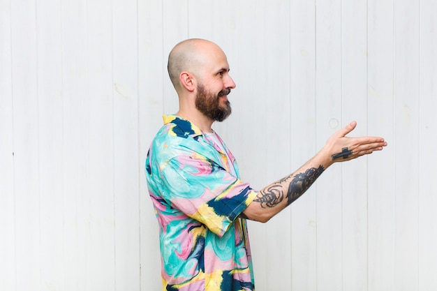 Bald man smiling, greeting you and offering a hand shake to close a successful deal, cooperation concept