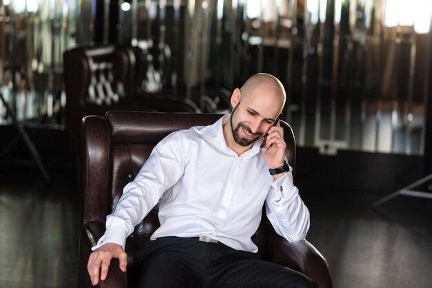 A bald man talking on the phone