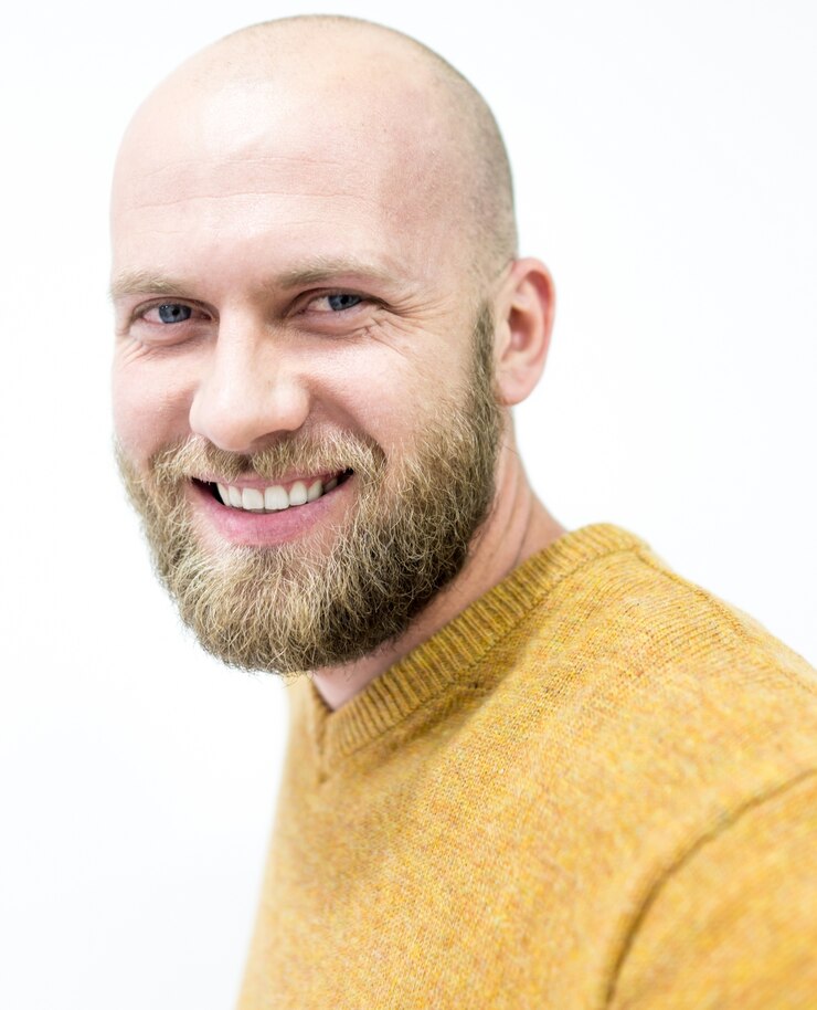 Bald young handsome man with blond beard smiling