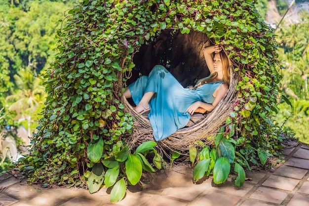 Bali trend stro nesten overal Jonge toerist geniet van haar reis rond Bali eiland Indonesië Stoppen op een prachtige heuvel Foto in een stro nest natuurlijke omgeving Lifestyle