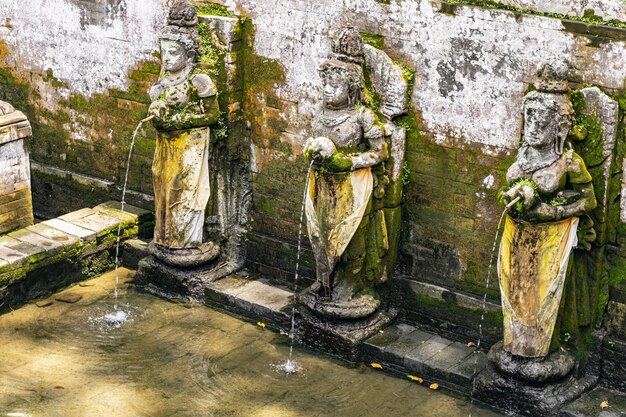 Balinese architecture. Old fountain being decorated with creative sculptures of goddesses in the exotic country