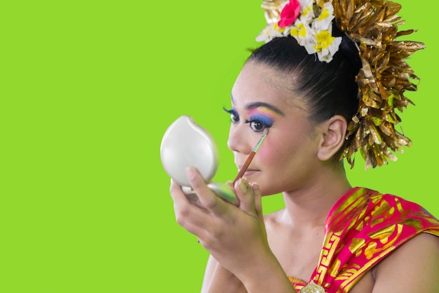 Balinese danseres die make-up maakt in de studio