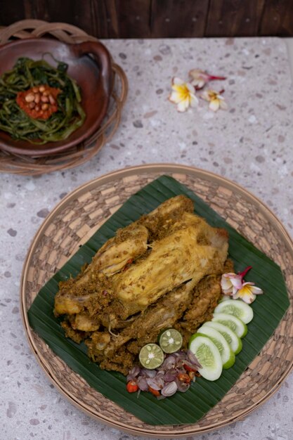 写真 ayam betutuという名前のバリのインドネシア料理。伝統的なサンバルとロースト ピーナッツを添えて。上