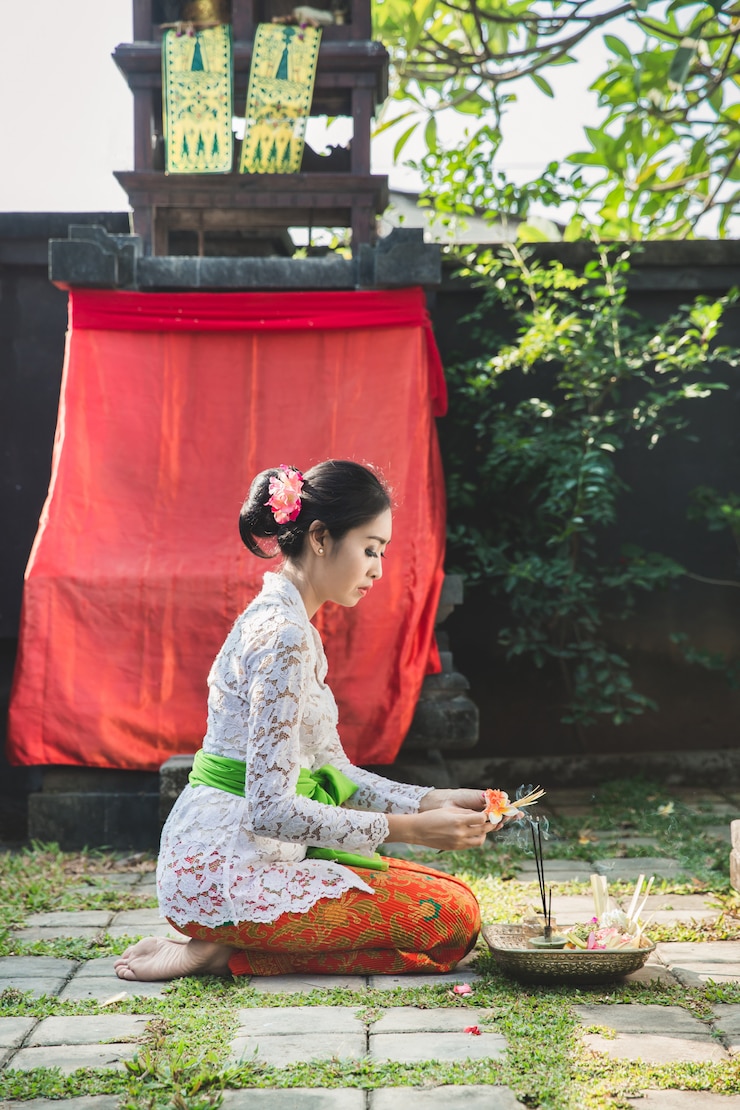 https://img.freepik.com/premium-photo/balinese-woman-praying-temple-small-shrines-houses_8595-9558.jpg?w=740