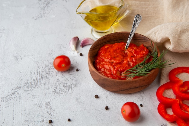 Balkan snack ajvar, lutenitza, pingjur with ingredients on a light space