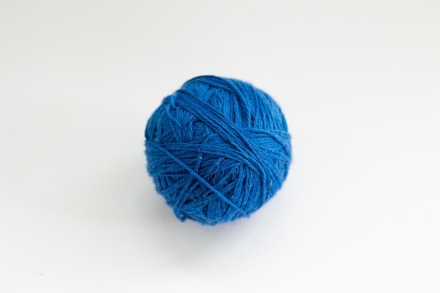 白い背景の上の青い糸のボール