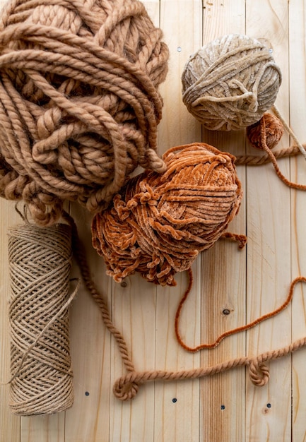 Ball of brown yarn on a wooden background view from above copyright