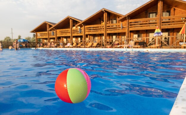 The ball floats on the water surface in the pool under the summer sun